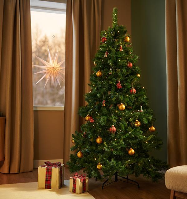 A decorated green Christmas tree with warm lights, gold baubles, and gifts underneath.