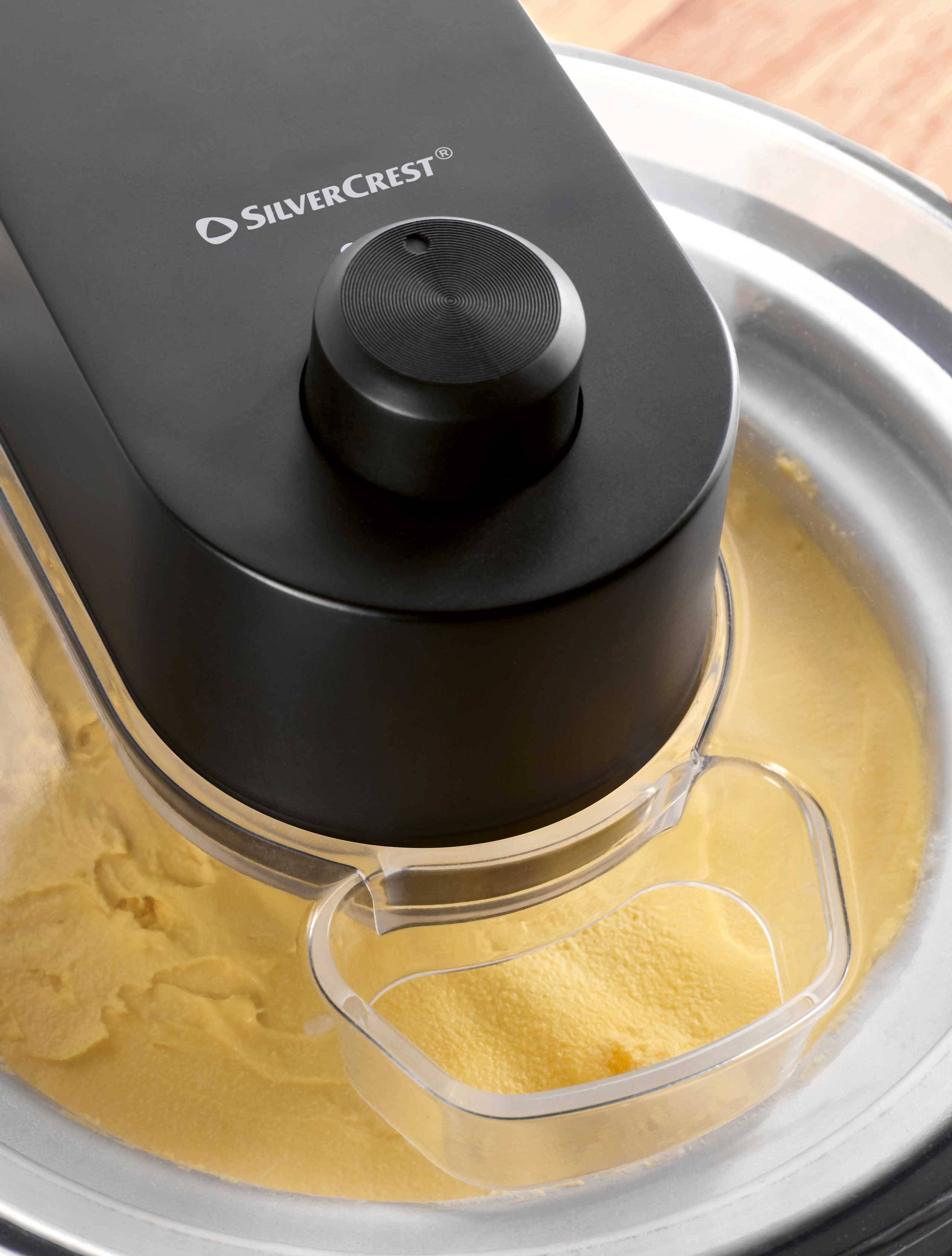 Ice cream maker with yellow mixture in a metal bowl.