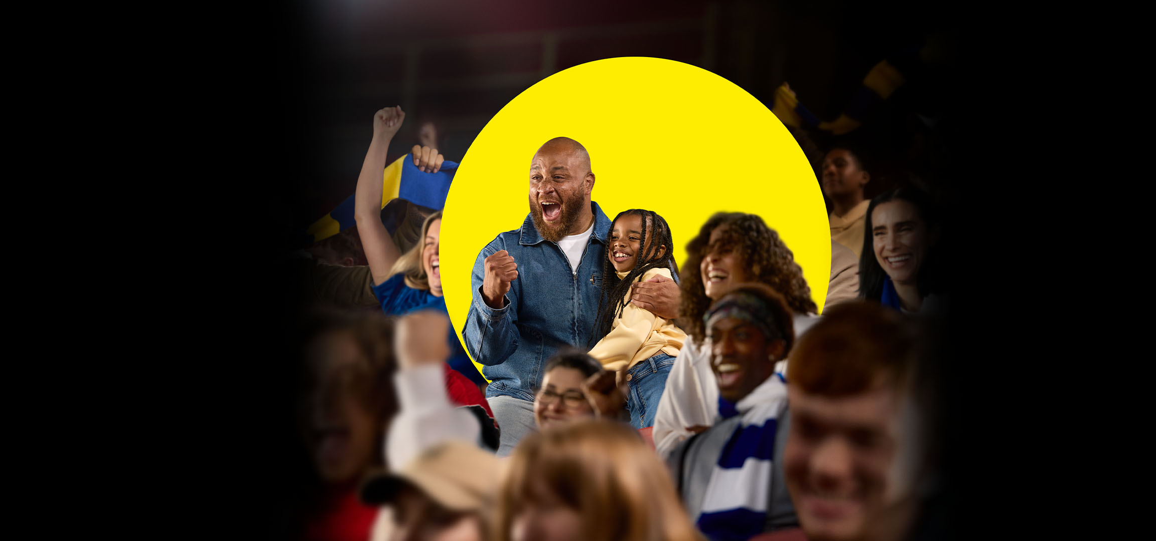 A smiling crowd of people, including a father and daughter, enjoying an event.