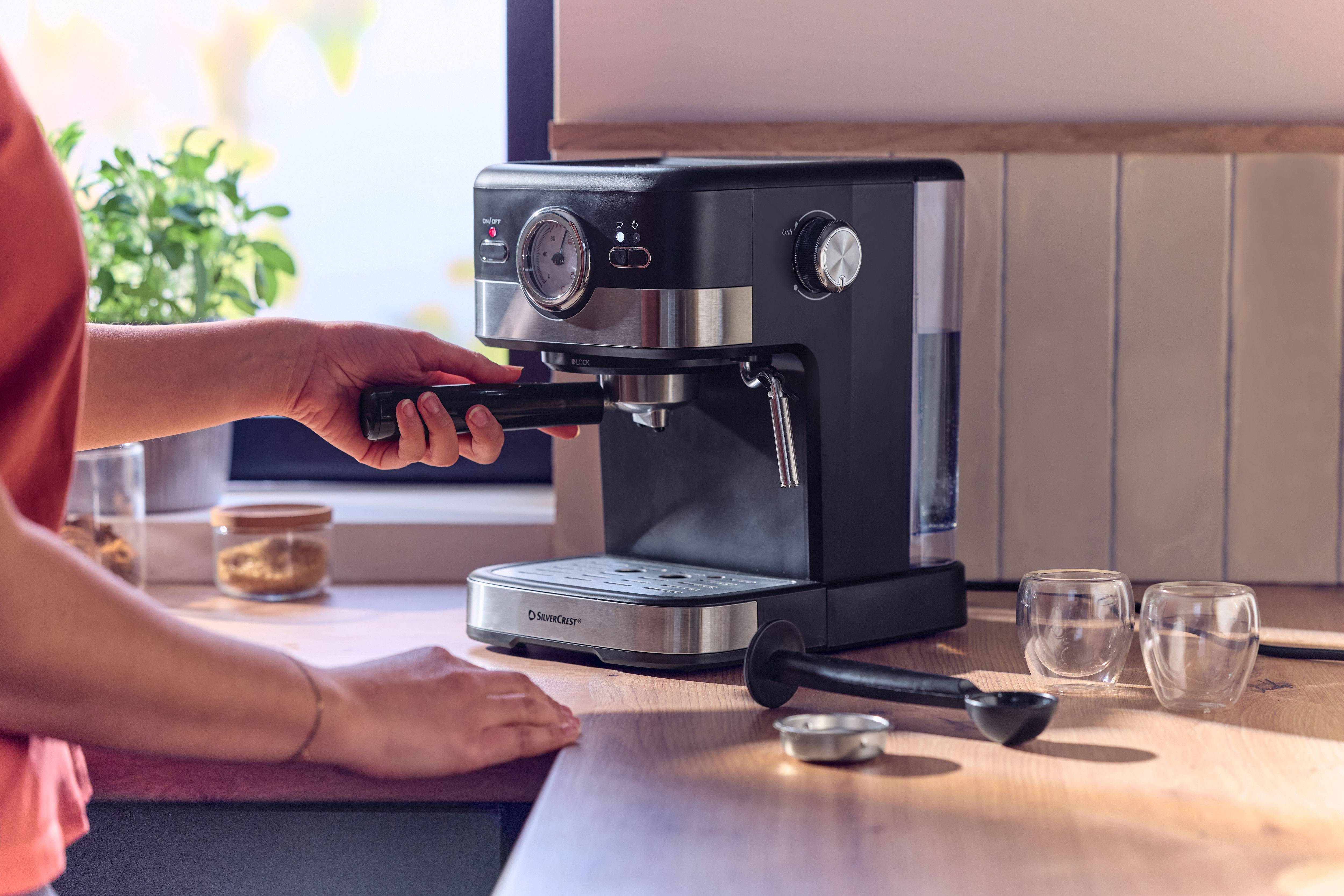 Espresso machine on a wooden countertop, person inserting portafilter.
