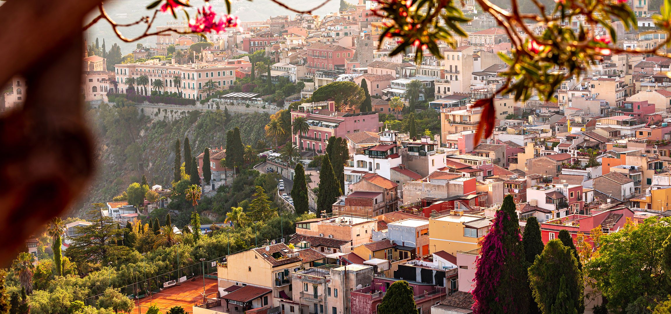 Panoramic view of a Mediterranean town with colorful buildings and greenery.