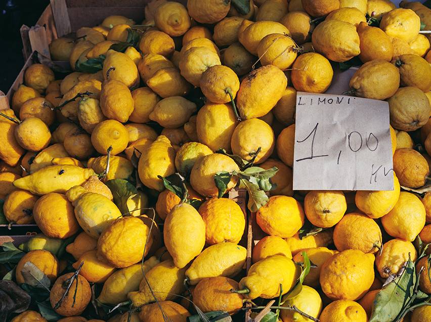 Fresh lemons for sale at a market, with a price tag of 1,00.