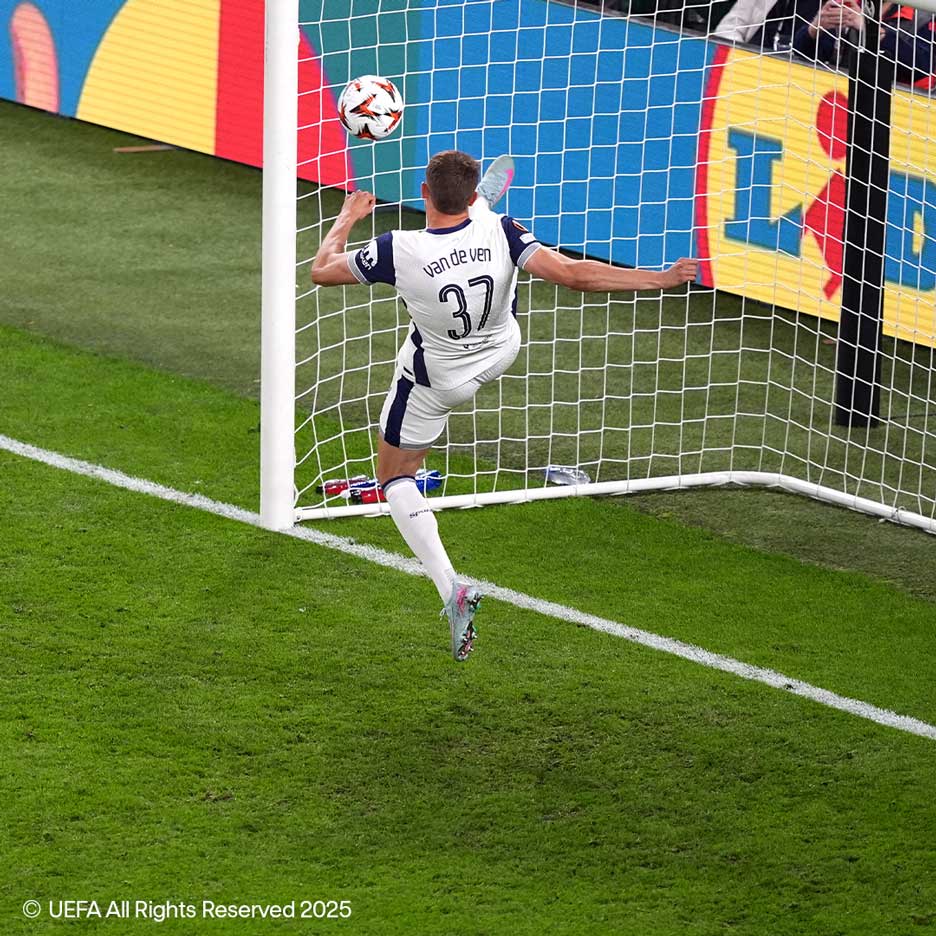 Football player in white jersey with number 37 kicking ball towards goal.