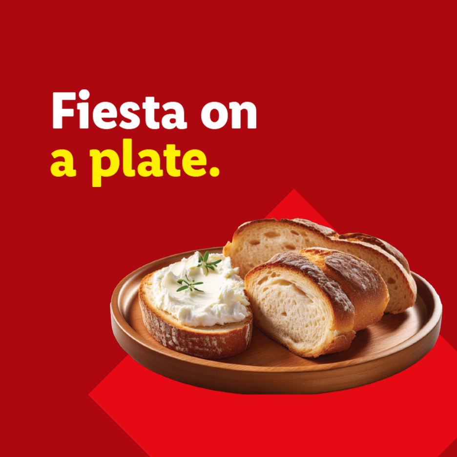 A wooden plate with sliced bread and a slice of bread topped with cream cheese and herbs, with text 'Fiesta on a plate.'