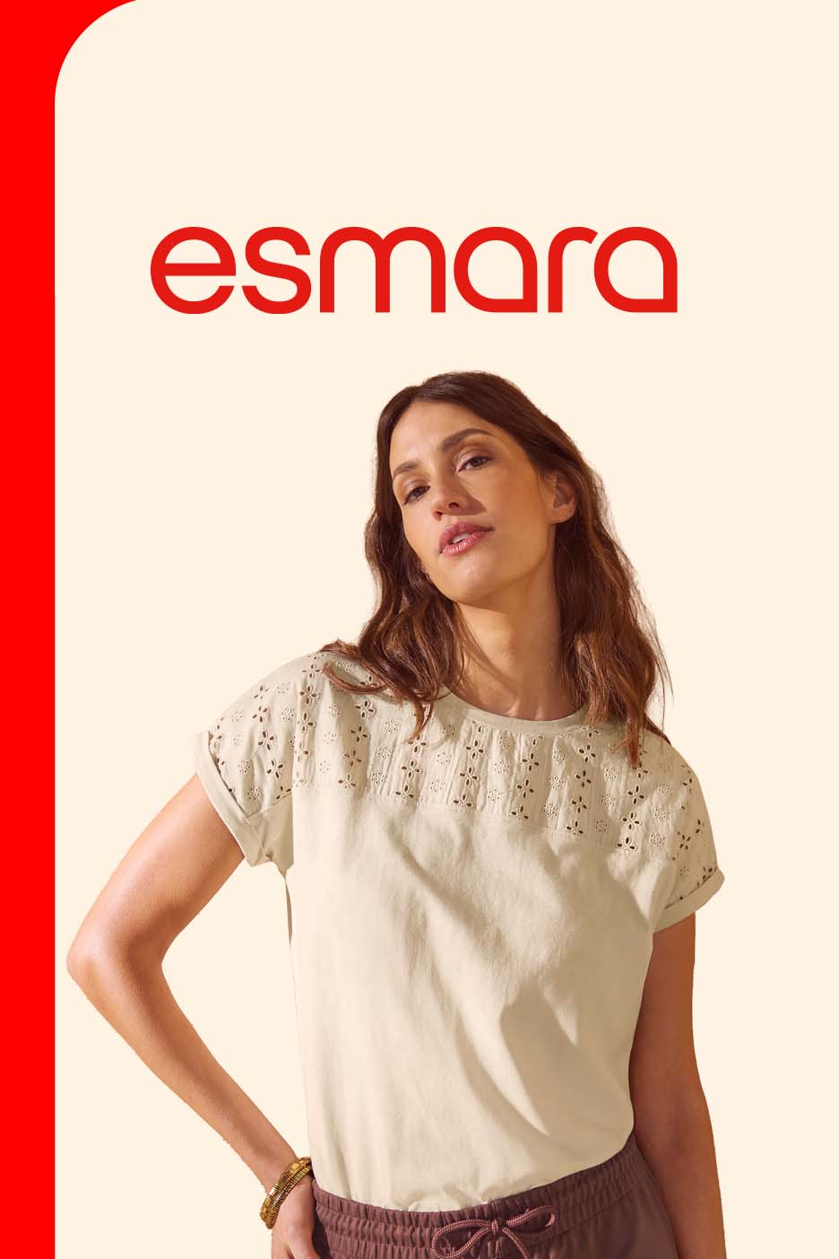 Woman in a light beige short-sleeved top with embroidered details, paired with brown trousers.