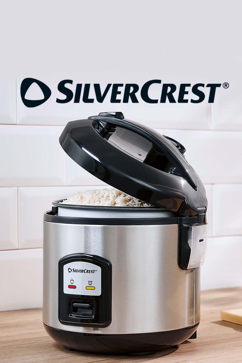 A stainless steel rice cooker with its lid open, filled with cooked white rice.