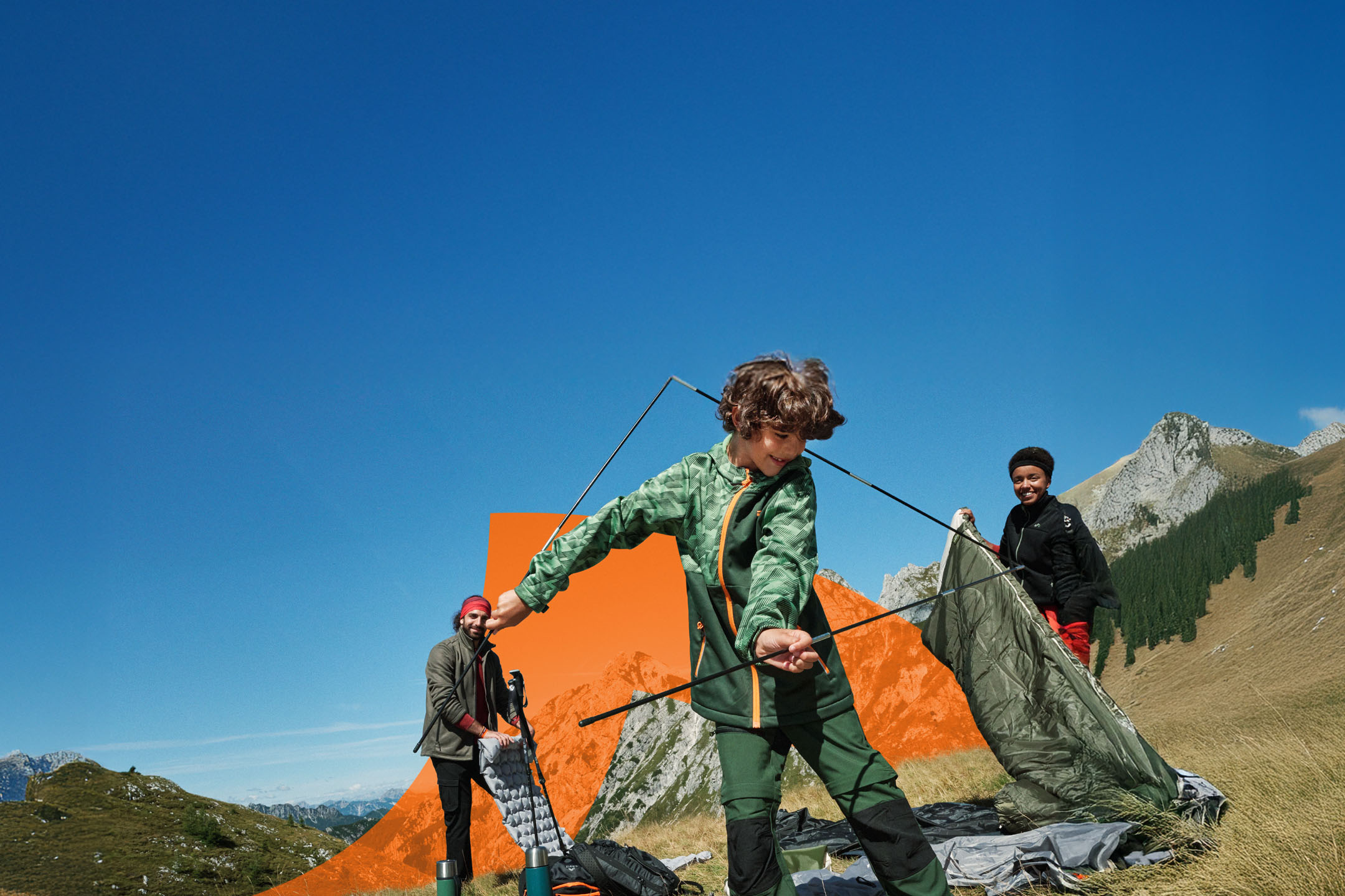 Family setting up a tent in the mountains, with camping gear and outdoor clothing.
