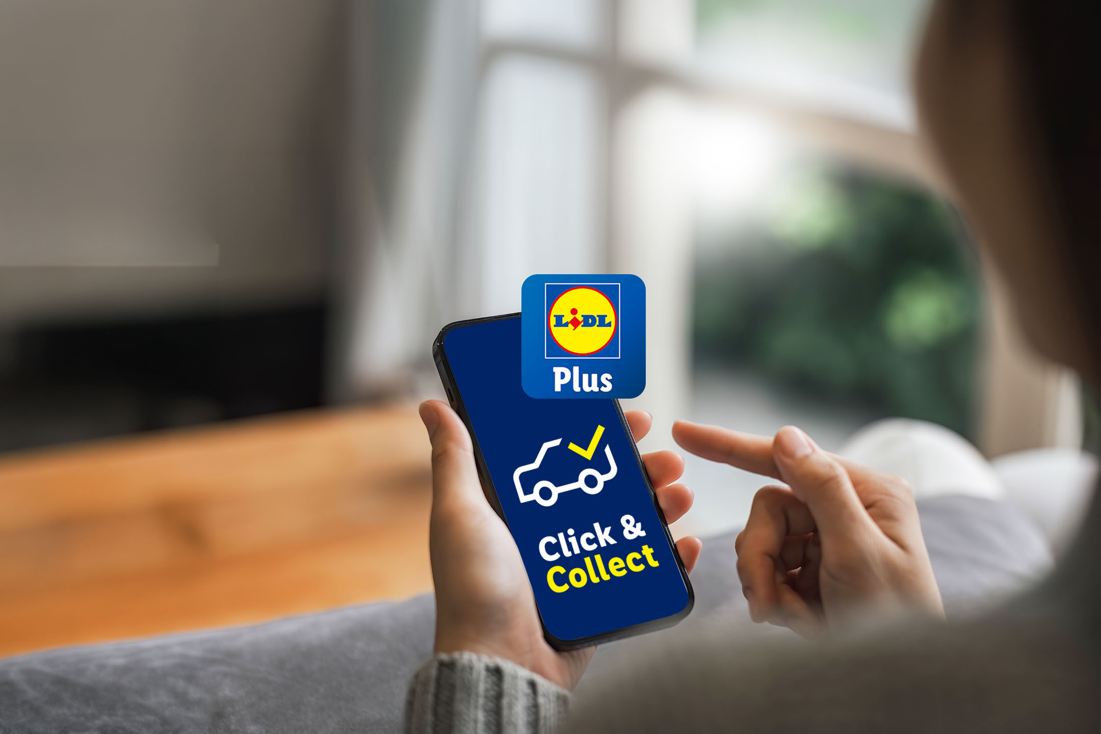 Person holding a smartphone with a 'Click & Collect' app, featuring a car icon.