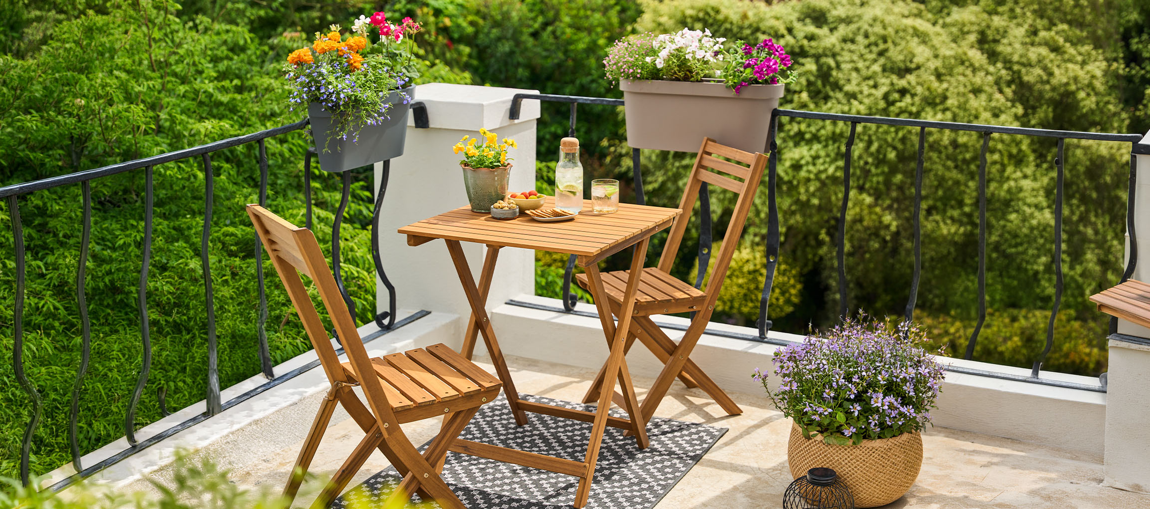 Balcony furniture set with a foldable table and chairs, decorated with flower pots.