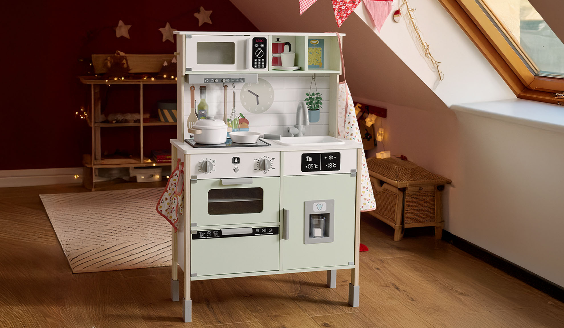 Wooden play kitchen with microwave, oven, and fridge in an attic room.