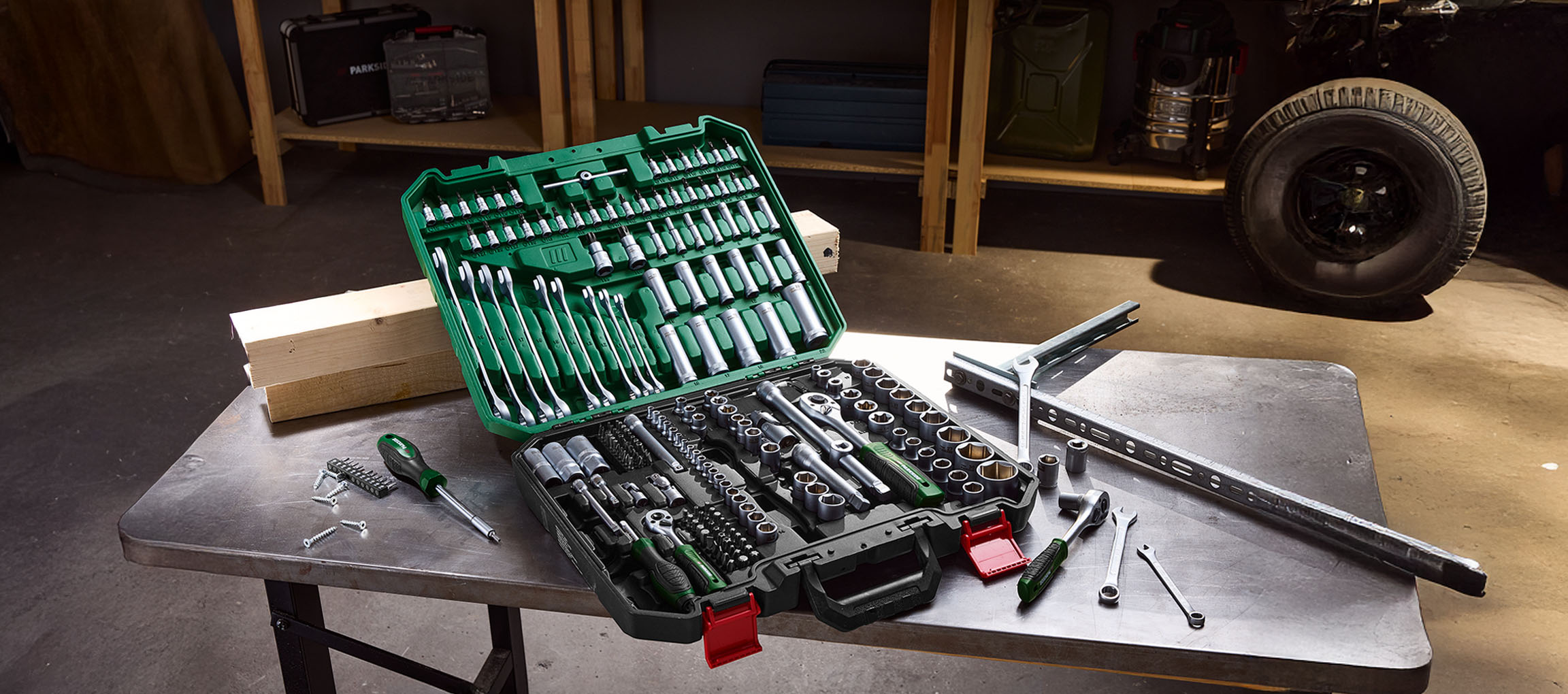 PARKSIDE tool set with wrenches, sockets, and screwdrivers on a metal table in a workshop.