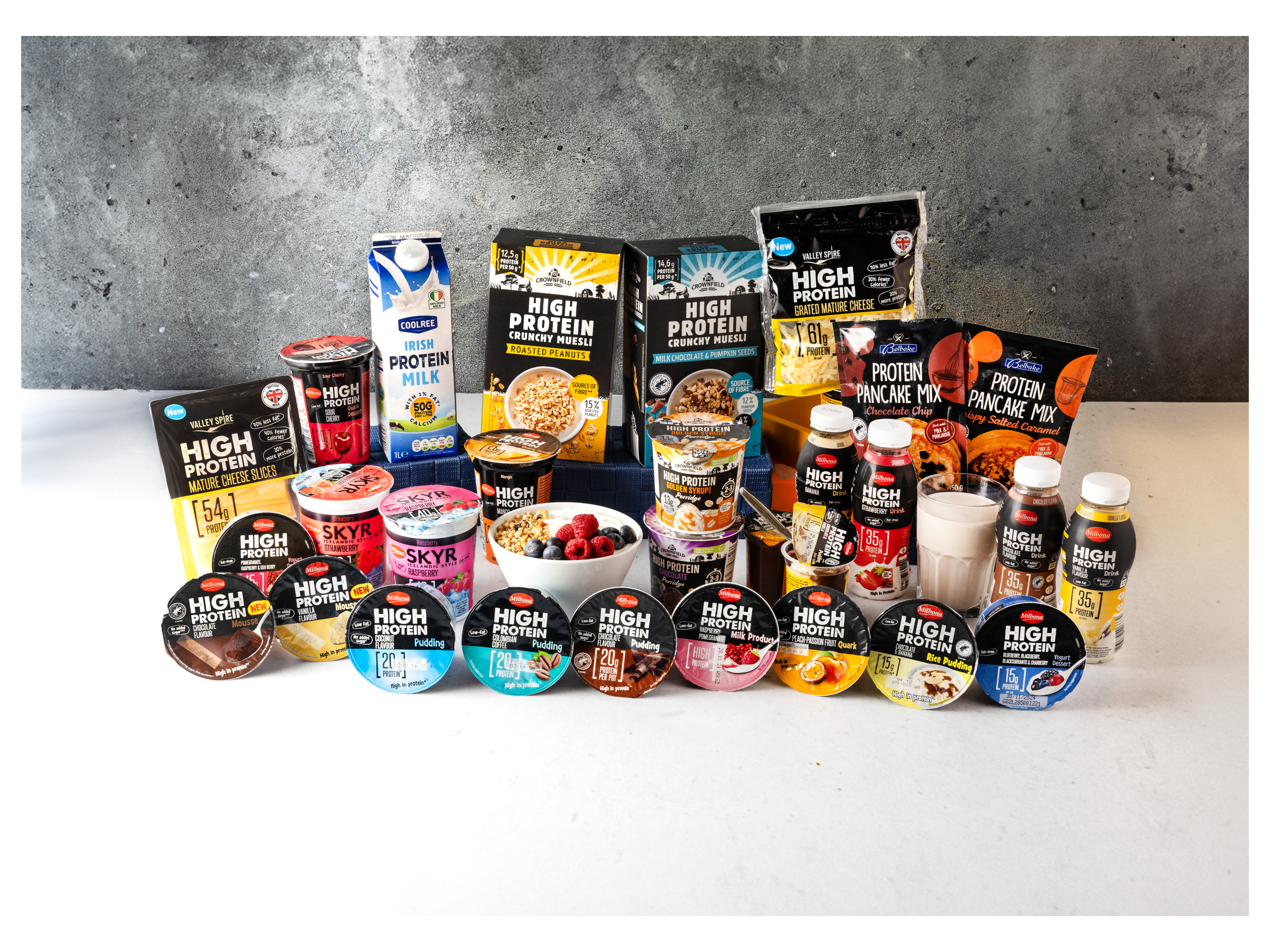 A variety of high-protein dairy products, muesli, and pancake mixes are displayed.