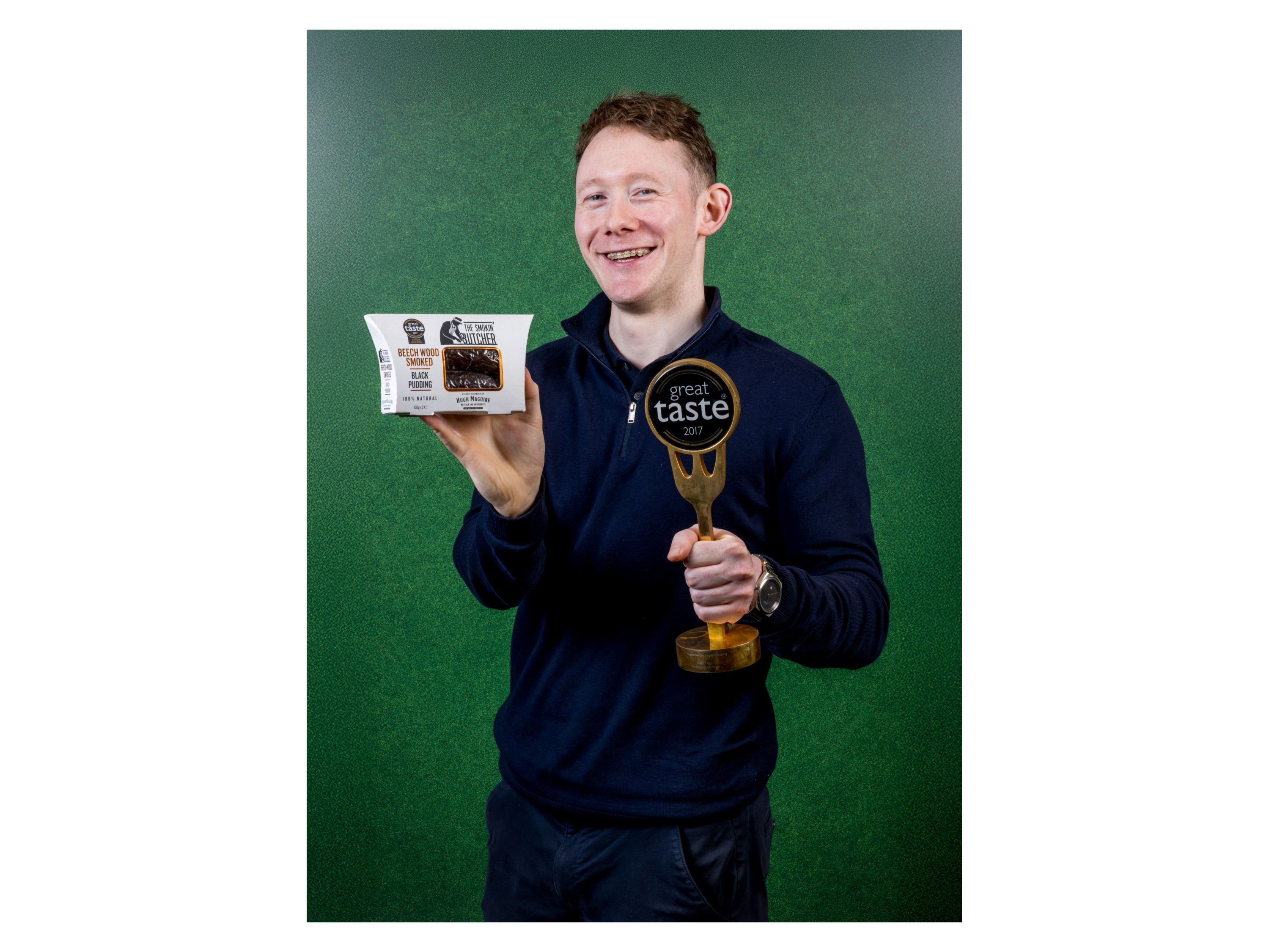 A man holding a package of Beech Wood Smoked Black Pudding and a Great Taste 2017 award.
